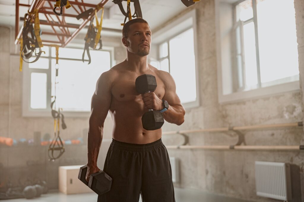 Young man going in for sport in gym